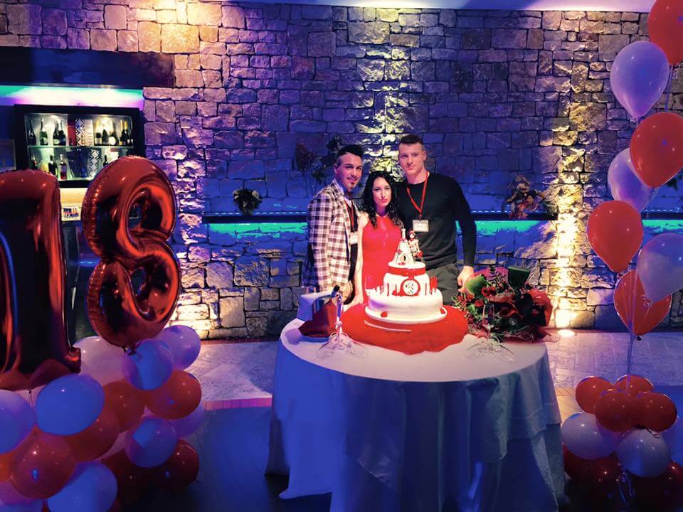Ragazza festeggia il diciottesimo compleanno con torta e palloncini colorati