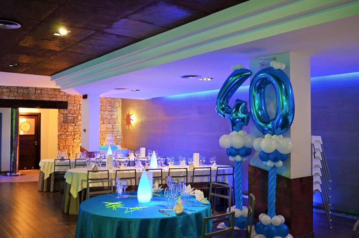 sala ricevimenti con palloncini blu e tavoli apparecchiati