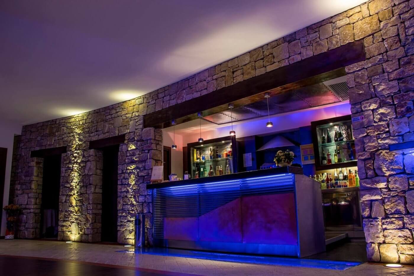 Spazio riservato all'area bar con mensole e luci eleganti, all'interno di una sala ricevimenti
